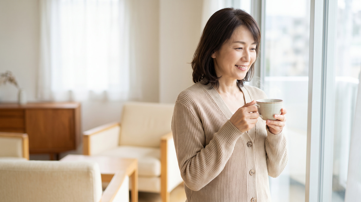 朝の光の中で温かい飲み物を持つ女性